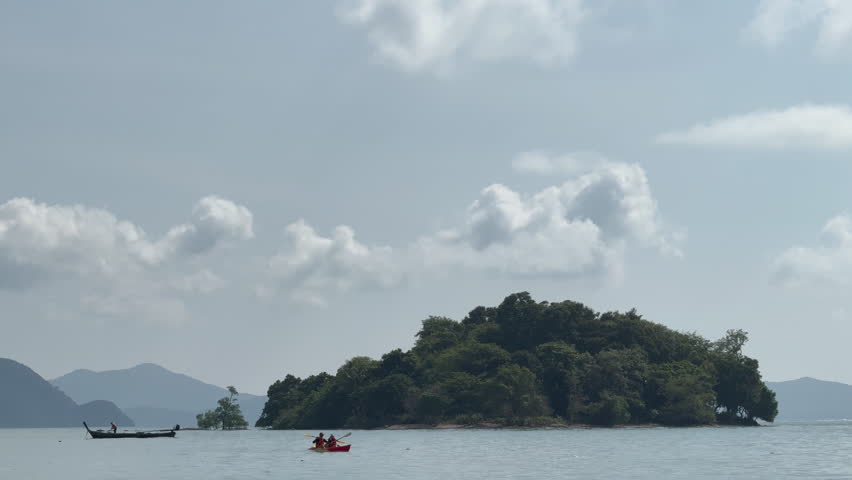 Thailand, November 2024 - Exotic shoreline with tourists enjoying canoe or sailboats sailing, tropical sandy beach and palm trees create a peaceful scenic landscape. Calm seashore.