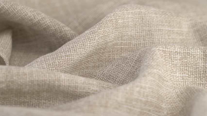 Beige natural fabric rotate in circle. Linen or cotton. Textile material tissue cloth. Texture fabric close up. Fabric background
