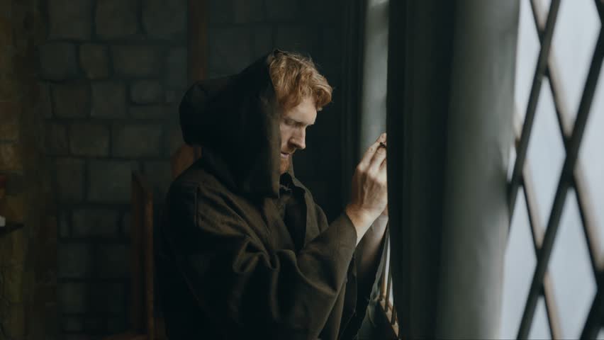 Thoughtful medieval monk praying in cathedral