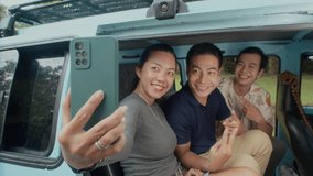 Adorable Asian woman holding smartphone while taking selfie with her friends, they sitting in back seat of minivan and posing - Powered by Shutterstock - Get 15% off with code: PIKWIZARD15