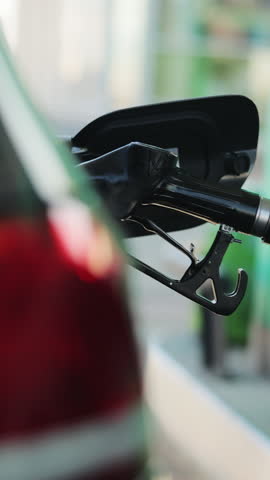 Vertical Video of businessman refueling car from gas station. Senior is refueling car at sunset. Caucasian businessman filling benzine gasoline fuel in car at gas station. Petrol prices concept.