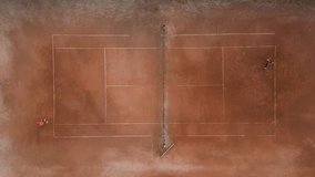 Aerial view of a clay tennis court with two players on opposite sides. The symmetrical composition highlights the white boundary lines, net, and scattered tennis balls on the textured surface - Powered by Shutterstock - Get 15% off with code: PIKWIZARD15