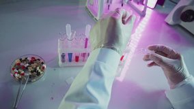 Laboratory professional accidentally breaking glass slide near test tubes and colorful medication pills, working in modern illuminated research environment - Powered by Shutterstock - Get 15% off with code: PIKWIZARD15