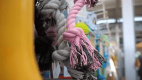 Close-up of knitted rope toys for dogs, for scratching teeth or playing, and a woman's hand touching them and choosing one. Shop, choosing a toy for a pet. - Powered by Shutterstock - Get 15% off with code: PIKWIZARD15