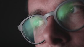 A man sits in front of a monitor with clouds reflecting in his glasses, showing the changing sky on the screen in a calm indoor setting. - Powered by Shutterstock - Get 15% off with code: PIKWIZARD15