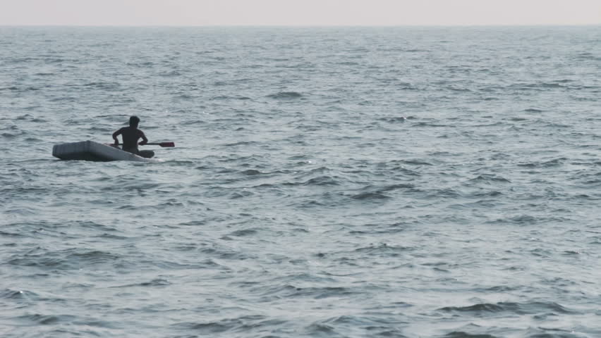 lone fisherman floating in sea on fishing - Kerala India