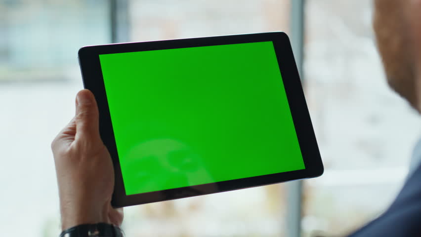 Businessman tapping chromakey tablet at corporate office closeup. Unknown manager shopping online using green screen pad computer at workplace. Man touching mockup display digital device in apartment.