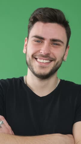 Portrait Of A Positive Relaxed Man Laughing On Green Background