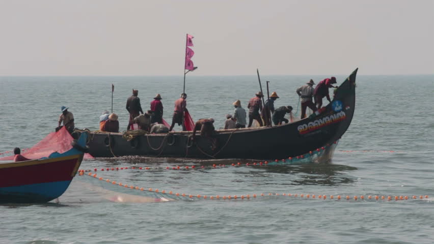 ALLEPEI, INDIA - DECEMBER 04, 2012: Fishermen in boats pulling fishing nets in