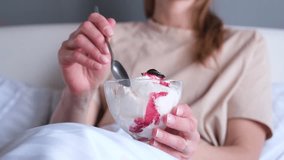 young Caucasian woman having ice cream in bed at home - Powered by Shutterstock - Get 15% off with code: PIKWIZARD15