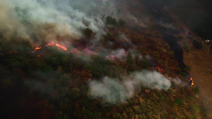 A drone captures flames devouring forests and fields, with thick smoke rising high. Prolonged drought makes wildfires more severe and frequent
