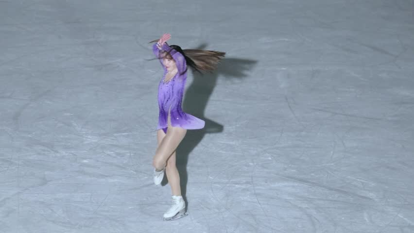 Figure skating. A figure skater girl skates alone in an ice arena at night.