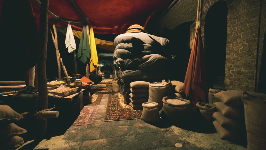 The bazaar displays a rich assortment of textiles and sacks, showcasing traditional craftsmanship. Visitors can explore the vibrant atmosphere and diverse offerings throughout the market.