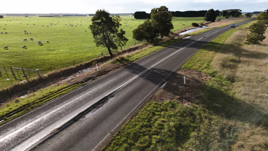 Car passing over pot holes on country Victorian road in Australia.
