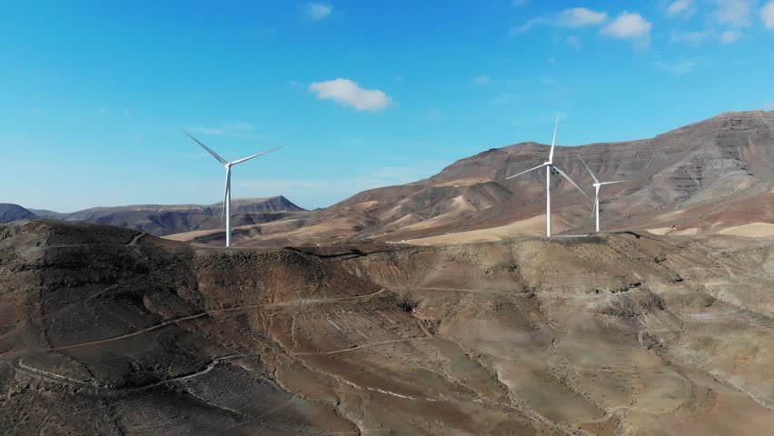 Wind turbines alternative energy production. Volcanic landscape of Fuerteventura island of Canary Islands, Spain.