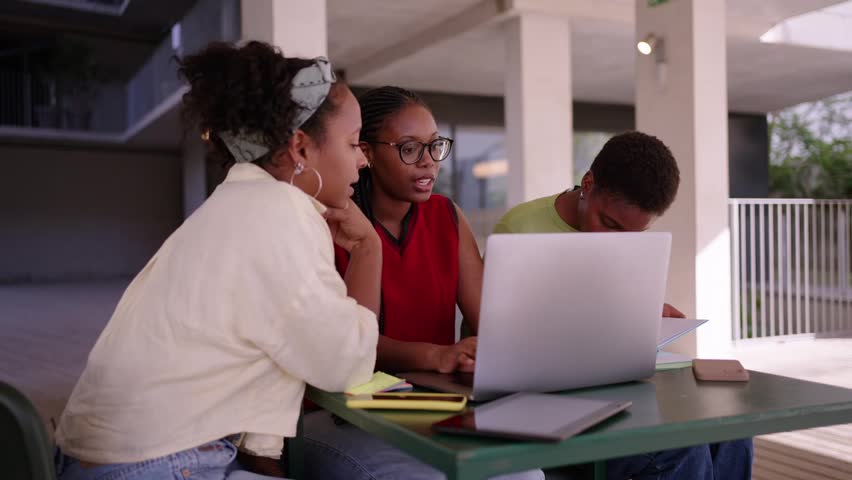 Group of African female friends gathering sitting in a table at university campus. Young women students studying using a laptop in the school cafeteria. Footage with copy space. - Powered by Shutterstock - Get 15% off with code: PIKWIZARD15