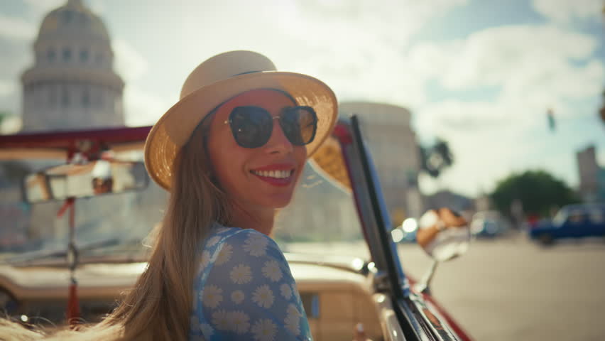 Happiness and joy of young adult blonde woman sitting in cabriolet in downtown. Amazing summer travel in beautiful country, enjoy summertime in Havana, luxury car and charming lady smiling to camera