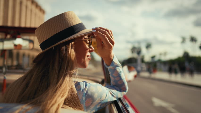 Rich woman on passenger seat in luxury auto traveling in summer holidays. Freedom and happiness in Cuba, be carefree and happy, enjoy summer vacation, tourism and travel, side view of beautiful lady