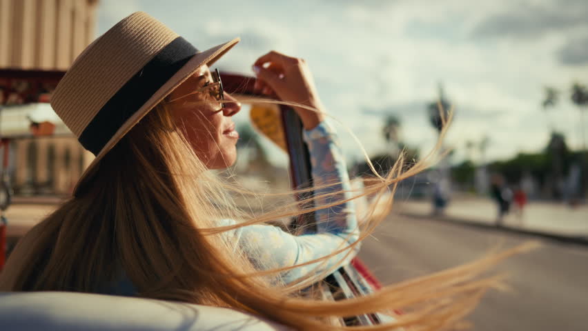Rich woman on passenger seat in luxury auto traveling in summer holidays. Freedom and happiness in Cuba, be carefree and happy, enjoy summer vacation, tourism and travel, side view of beautiful lady