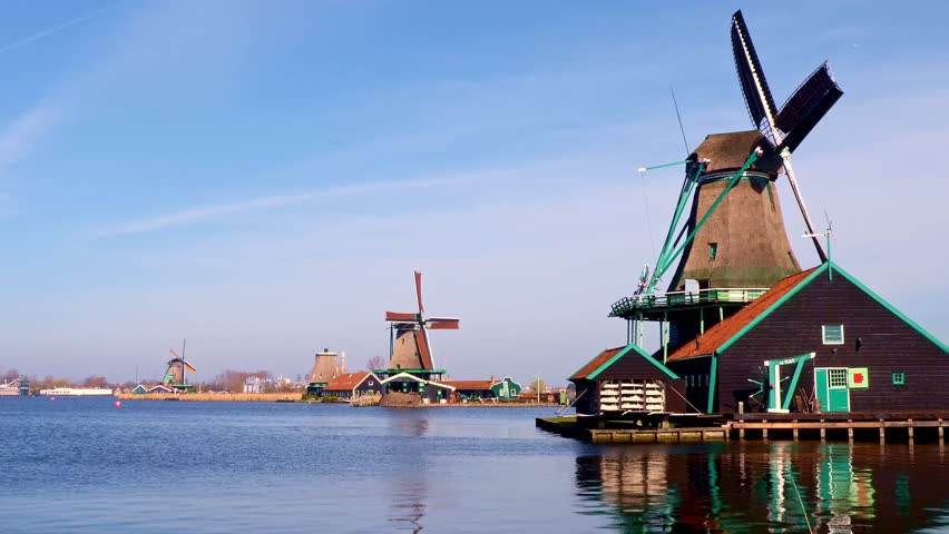 A drone footage of the historic mills at the Zaanse Schans on the River Zaan on a sunny day in the province of North Holland, Netherlands