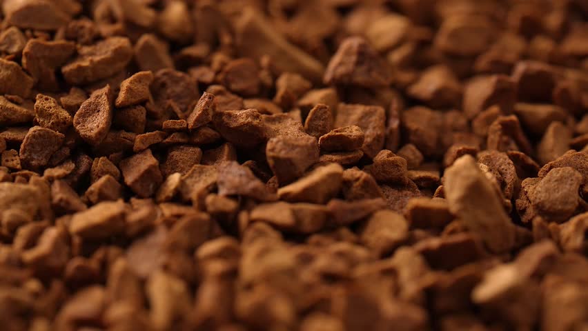 A closeup footage of a rotating pile of freeze-dried instant coffee, with blurred background
