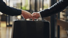 Suited man hands over a suitcase to another, secrecy and suspicion. Government conspiracy or corporate fraud and political corruption.Handshake finalizes transaction. Power and deception collusion - Powered by Shutterstock - Get 15% off with code: PIKWIZARD15