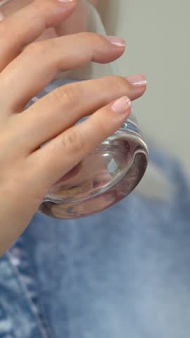 Close up of woman takes pill and drinks with water. Tablets and drugs, medicament, vitamins, contraceptives. Medicine and health care. Vertical shot