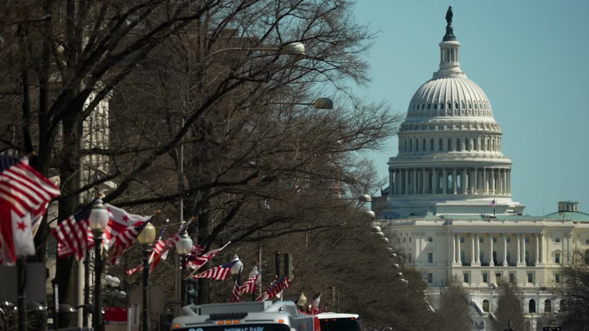 On a clear day, flags line the street, providing a vibrant view towards the US Capitol building in Washington, showcasing the citys iconic architecture.