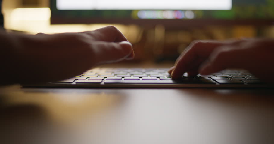 Female worker focused on laptop keyboard while working from home remotely