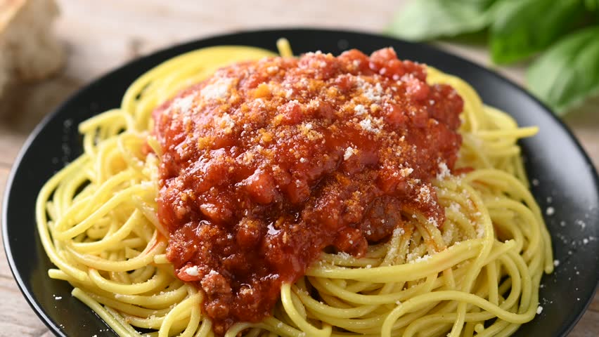 Spaghetti with bolognese sauce on wooden table