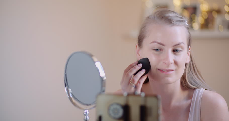 Woman getting ready in morning, applying makeup before leaving for work, close up beauty prep