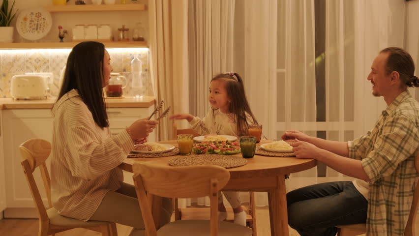Happy family having dinner together at cozy kitchen table