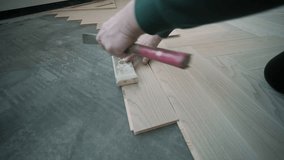 Worker installing wooden flooring with hammer and tapping block - Powered by Shutterstock - Get 15% off with code: PIKWIZARD15