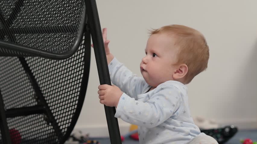 In a bright, cheerful space filled with colorful toys, a curious baby joyfully explores a cozy chair, embodying their innate spirit of discovery and curiosity about the world