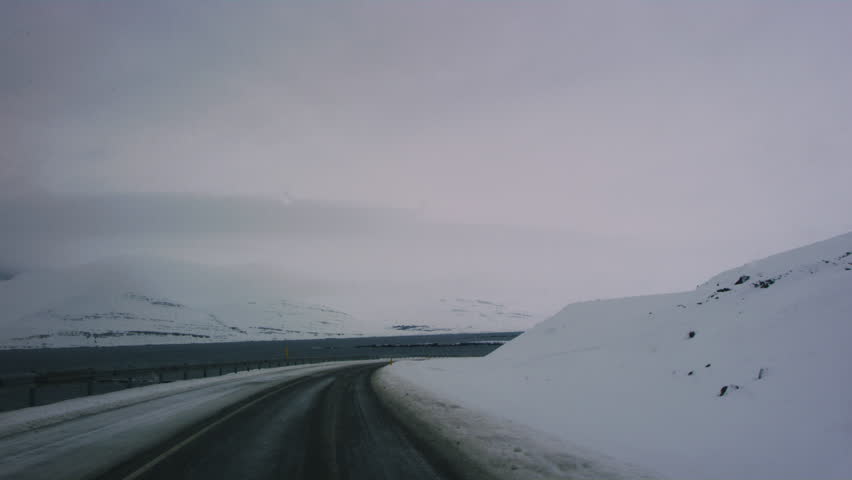 Remote Arctic highway covered in snow surrounded by Iceland’s dramatic winter scenery