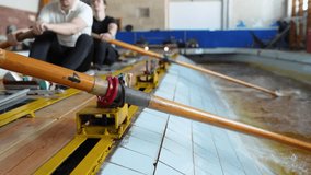 Synchronized athletes training for rowing competition indoors. Group of rowers practicing in sports facility with rhythmic move of oars in sports water simulator building strength, endurance, teamwork - Powered by Shutterstock - Get 15% off with code: PIKWIZARD15
