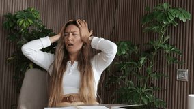 Stressed young businesswoman overwhelmed with work, searching notes, holding head in frustration, concept of burnout, deadline pressure, remote work overload - Powered by Shutterstock - Get 15% off with code: PIKWIZARD15