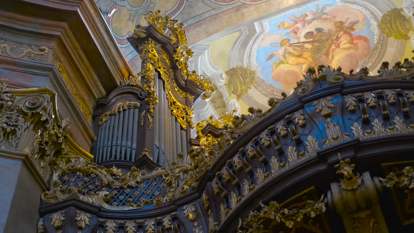 Vienna, Austria, September 15, 2024. Architectural beauty of a church organ loft. Intricate carvings and golden accents enhance a church organ loft, while religious frescos, rich architectural details