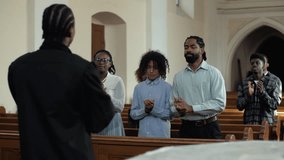 Joyful congregation members clapping and singing, led by their pastor, during a vibrant church service - Powered by Shutterstock - Get 15% off with code: PIKWIZARD15