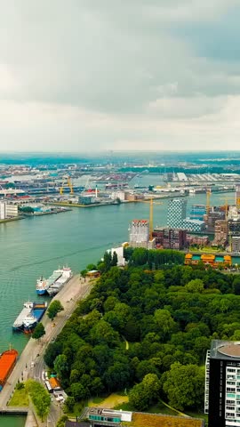 Vertical video. Rotterdam, Netherlands. View of the port. River Nieuwe Maas. Summer day, Rainy clouds, Aerial View, Departure of the camera. Rich colors