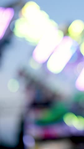 Blurred lights of a spinning carnival ride at dusk