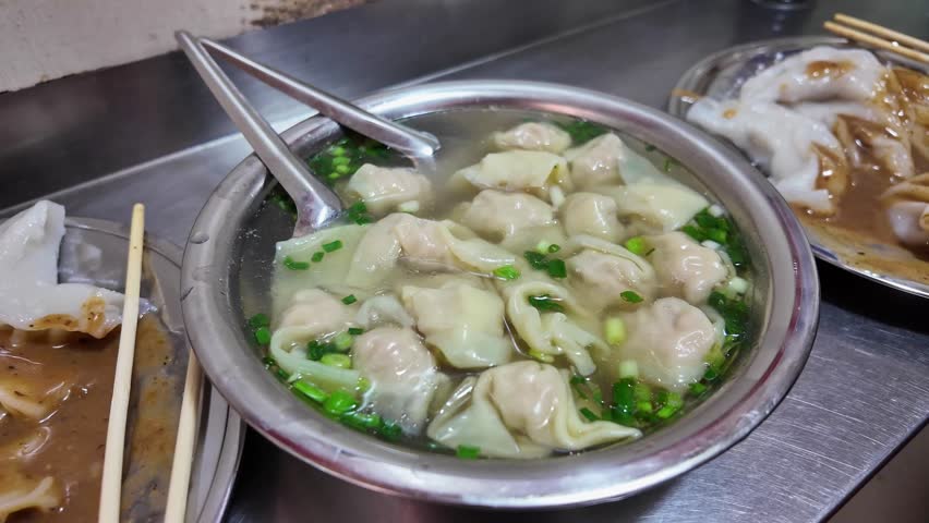 A diner eats a bowl of wontons in Nanning, Guangxi, China