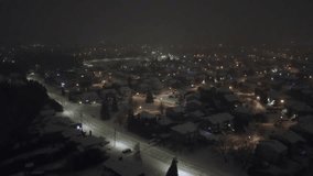 Snow gently falling at night, blanketing the illuminated houses and quiet streets of St Constant, Quebec, Canada, creates a serene winter scene filled with holiday charm - Powered by Shutterstock - Get 15% off with code: PIKWIZARD15