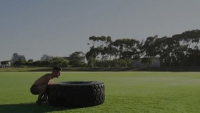 Man flipping tire on grass with financial data animation overlay. Exercise, fitness, determination, outdoors, strength, finance - Powered by Shutterstock - Get 15% off with code: PIKWIZARD15