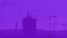 Silhouetted construction cranes with financial data animation on purple background. Infrastructure, development, finance, economy, growth, technology - Powered by Shutterstock - Get 15% off with code: PIKWIZARD15