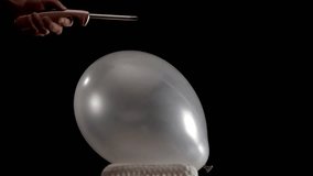 A silver balloon rests still as a hand lights a small flame on a lighter and slowly moves it closer. The tension builds until the balloon pops dramatically, captured in stunning slow motion. - Powered by Shutterstock - Get 15% off with code: PIKWIZARD15