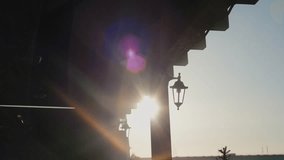 Soft sunbeams illuminating swirling dust particles under wooden roof structure during golden sunrise, creating ethereal atmospheric light effect near vintage lamppost - Powered by Shutterstock - Get 15% off with code: PIKWIZARD15