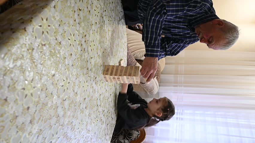 Engaging in a delightful game with family, balancing blocks on a cozy afternoon