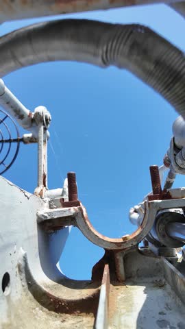 Detailed view of a vintage naval artillery mount with a metal operator seat and mechanical components, displayed on a decommissioned military ship.