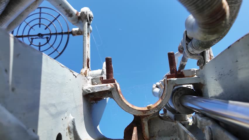 Detailed view of a vintage naval artillery mount with a metal operator seat and mechanical components, displayed on a decommissioned military ship.